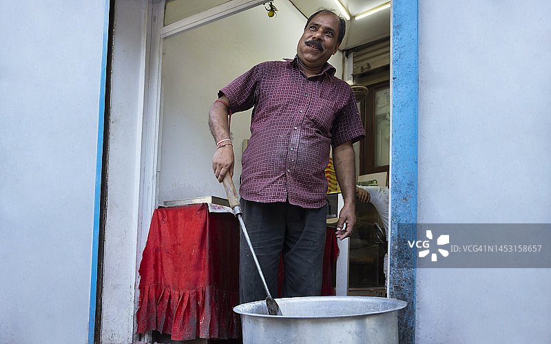 一家被称为Halwai的糖果店的老板正在他的糖果店的厨房里制作Gulab jamun，这是一种很受欢迎的印度小吃图片素材