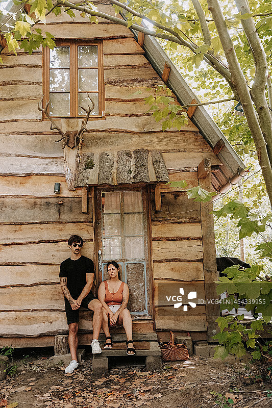 一对成年夫妇站在木屋门口图片素材