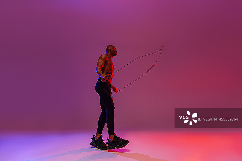 男子跳绳工作室背景跳绳。力量和动力。最佳有氧运动图片素材