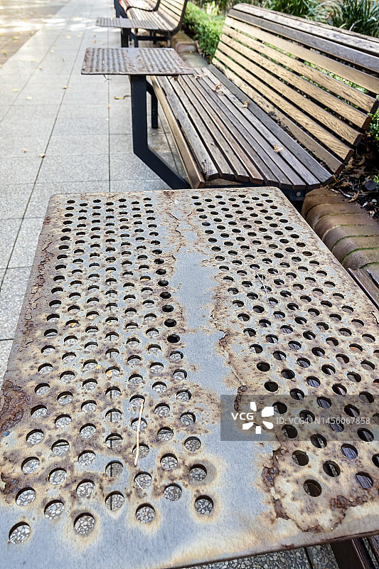 生锈的公园长凳，用铁板制成，上面有穿孔。图片素材