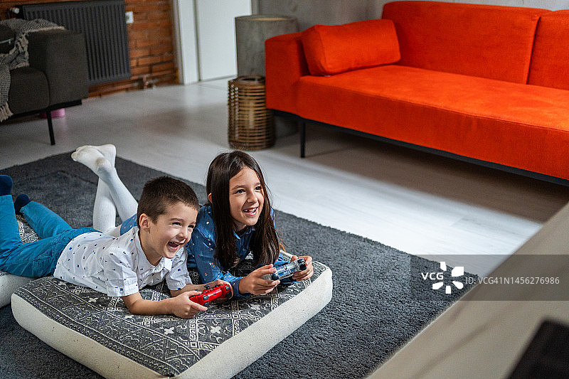 哥哥和妹妹在家里的客厅玩电子游戏图片素材