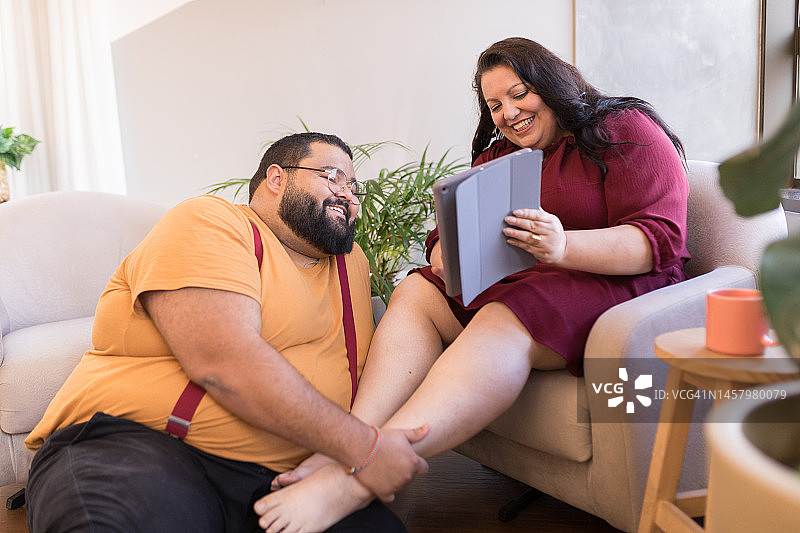 幸福的夫妻在平板电脑上展示彼此的东西图片素材