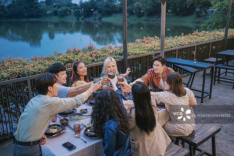 亚洲华人朋友在户外用餐时举杯庆祝图片素材