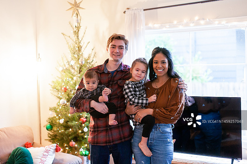 圣诞树旁的家庭和两个孩子的肖像图片素材