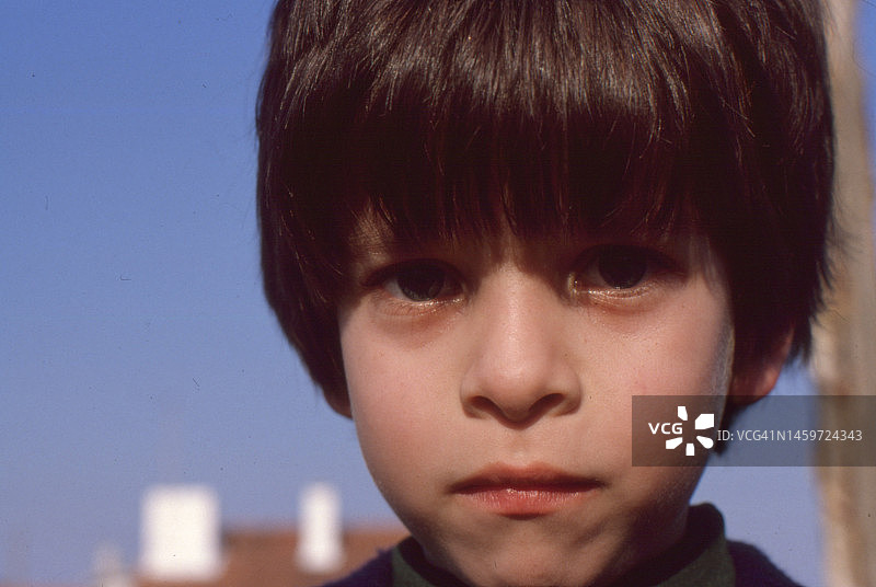 1979年，乌拉圭蒙得维的亚海滩上寒冷的一天，一个小男孩的复古特写照片图片素材
