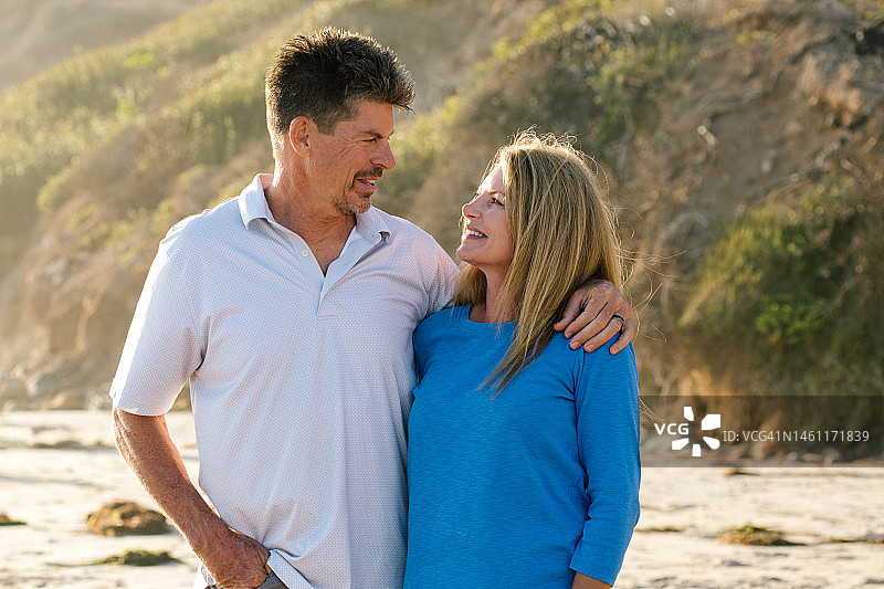 丈夫和妻子在海滩上互相微笑的照片图片素材