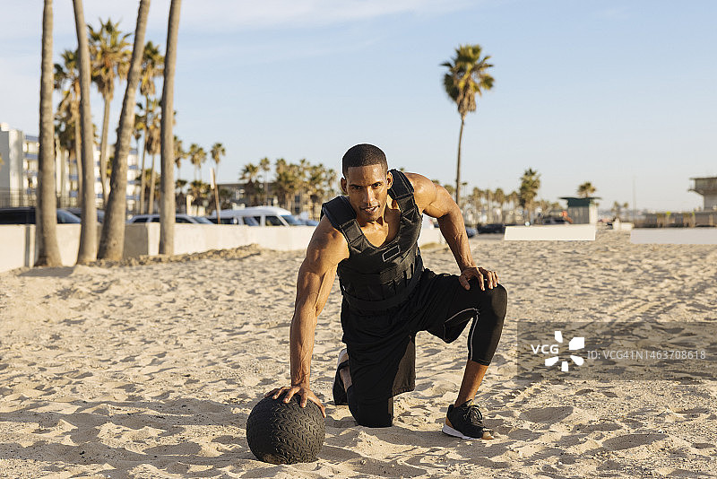 活跃的运动员在沙滩上用球锻炼图片素材