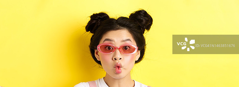 夏日时尚概念傻傻的迷人女孩戴着墨镜，撅起嘴唇图片素材