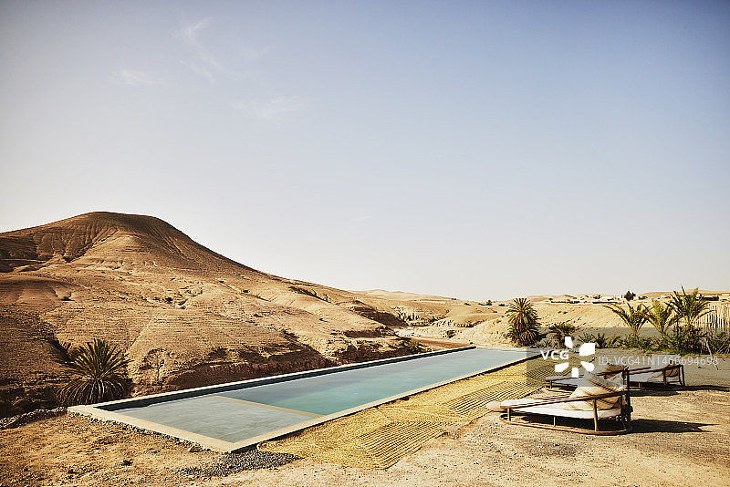 摩洛哥沙漠营地游泳池和躺椅的广角镜头图片素材