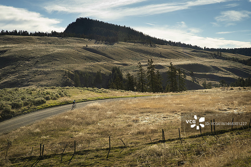 在加拿大不列颠哥伦比亚省坎卢普斯附近的风景秀丽的乡间土路上骑自行车图片素材