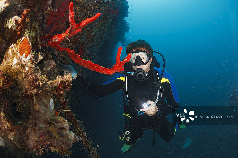 男子水下水肺潜水有雾潜水面罩的问题。海洋生物红珊瑚礁在沉船水下照片水肺潜水员的观点。图片素材
