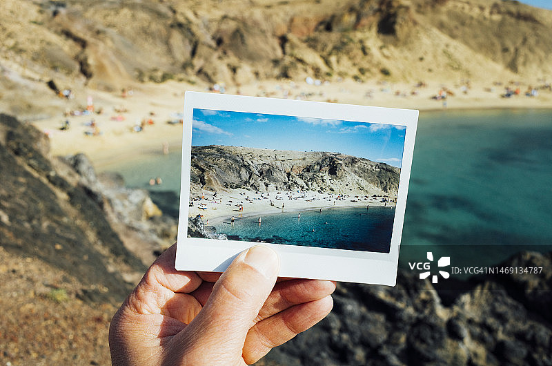 男子拿着一个繁忙的海滩海湾在现场前的即时胶片照片图片素材