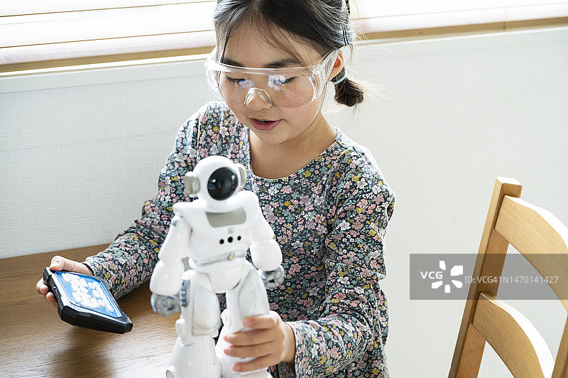 一个小女孩在做一个玩具机器人图片素材