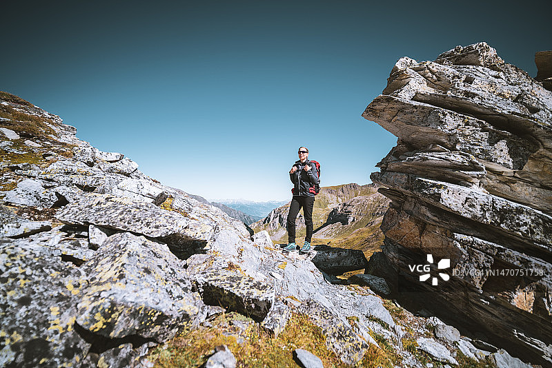 徒步旅行的女人站在山中的岩石之间图片素材