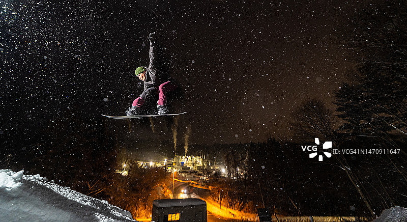滑雪板运动员在晚上跳图片素材