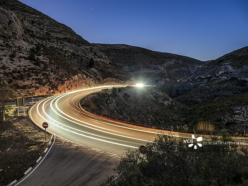 高架视图的椭圆曲线的痕迹，在夜间超速汽车。图片素材