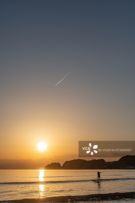 飞机飞过日本神奈川的日落海滩图片素材