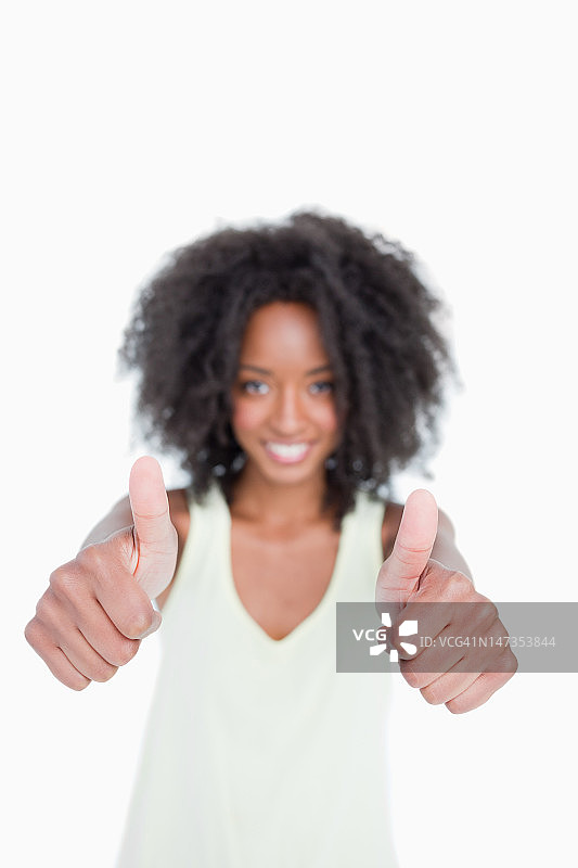 一位年轻的卷发女子竖起大拇指图片素材