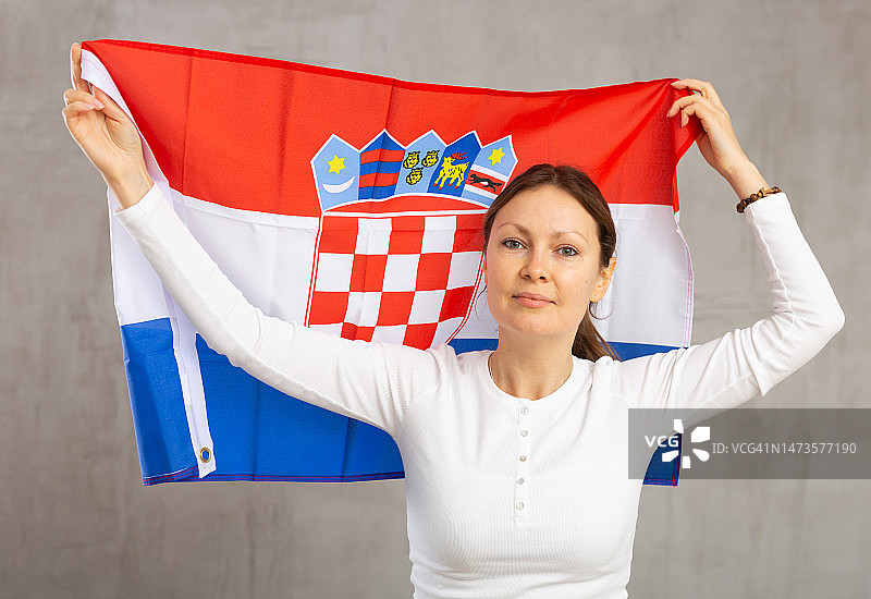 微笑的女人摆着克罗地亚国旗在工作室图片素材