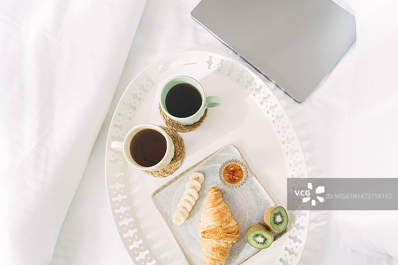 Beautiful breakfast at the hotel or café, croissant with fruit and a cup of coffee.图片素材