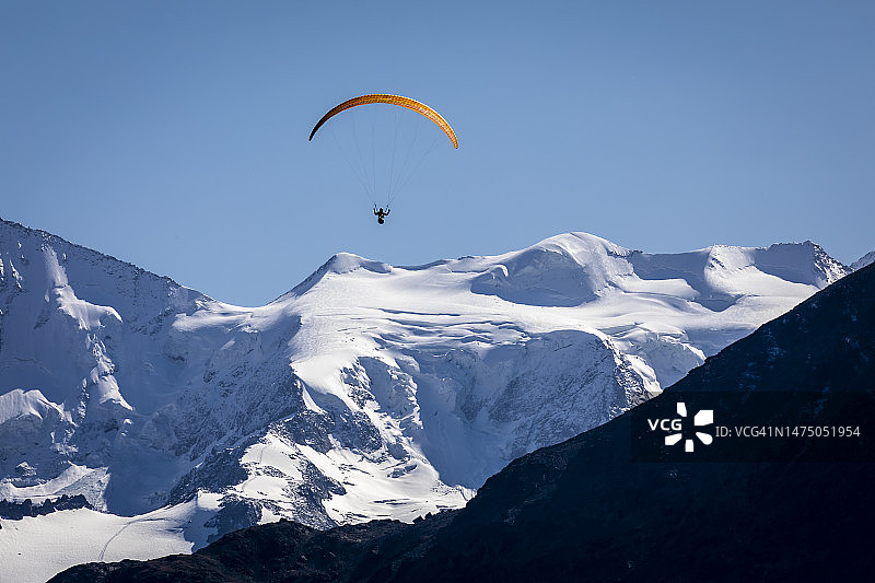 在瑞士阿尔卑斯山脉格劳宾登恩加丁山谷的Muottas Muragl的高山景观上滑翔伞图片素材