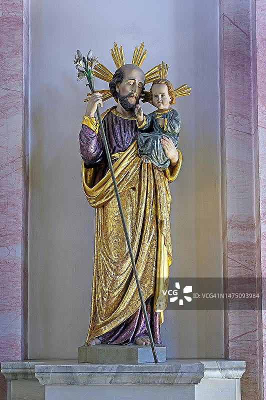 圣约瑟夫与莉莉和圣婴耶稣，受遗产保护的罗马天主教圣母升天教堂是德国巴伐利亚州阿尔加乌Kempten地区Kottern的一座新巴洛克式的神圣建筑图片素材
