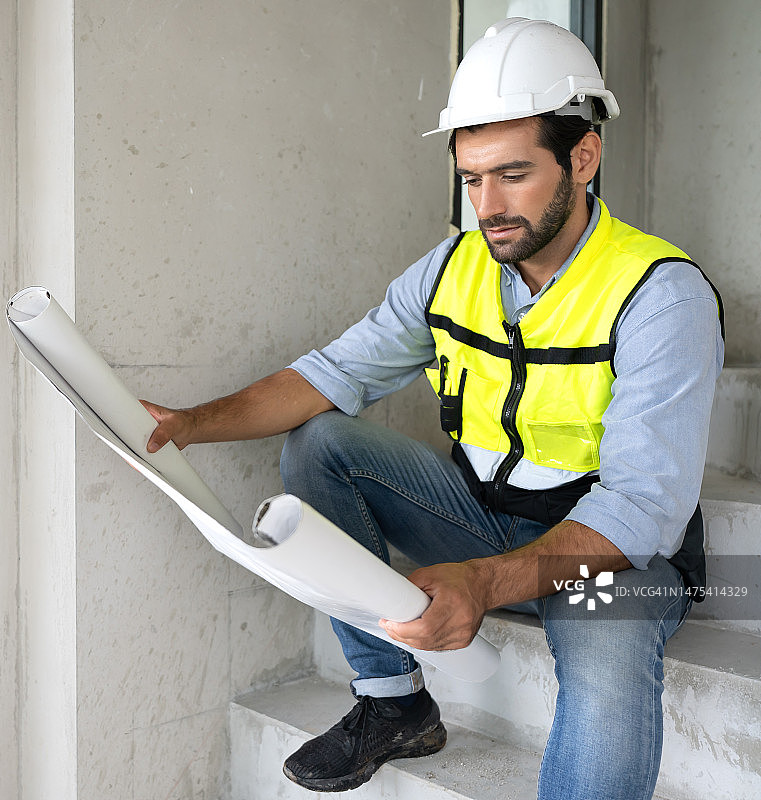 专业的建筑师戴着安全安全帽，从事家庭室内和住房开发项目。图片素材