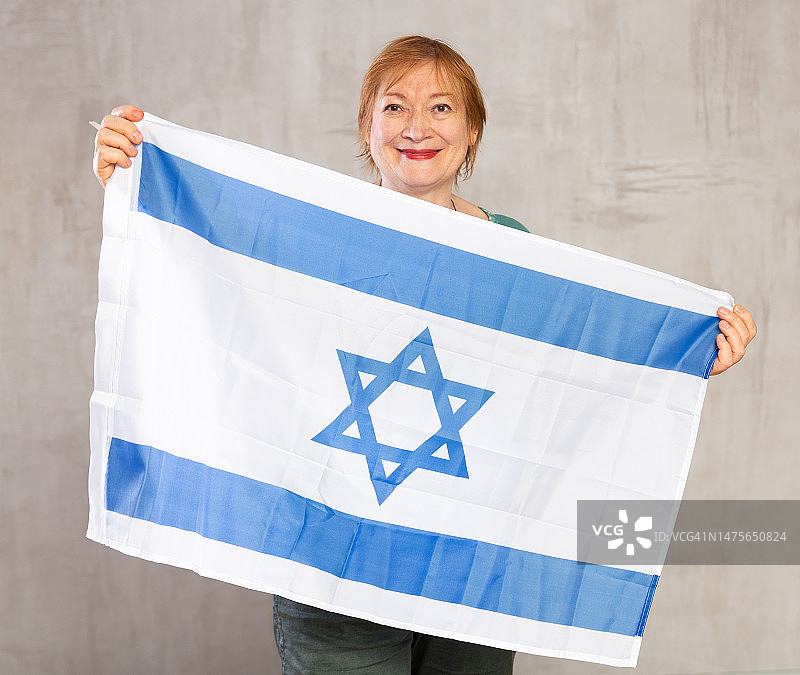 快乐的老年妇女挥舞着以色列国旗图片素材
