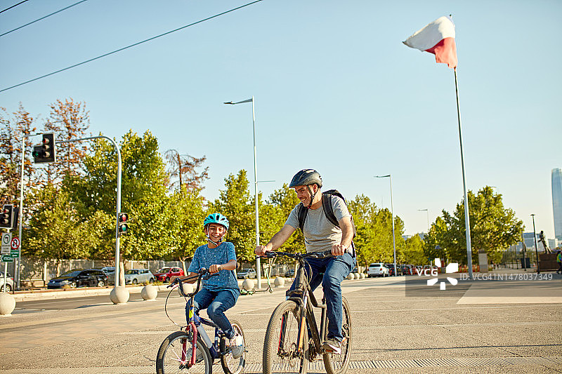 微笑的父亲和年幼的儿子在周末骑自行车图片素材