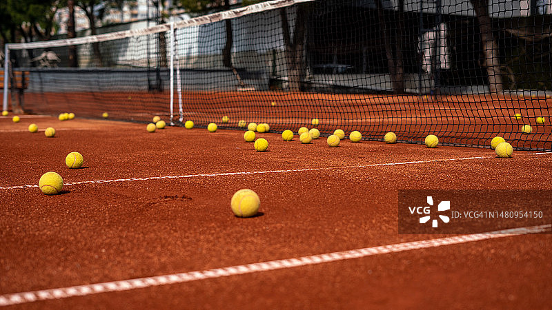 网球在网球网前的红土场上图片素材