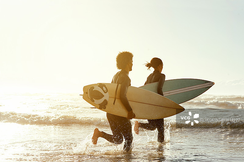 男人、女人和冲浪一起在海边跑步健身，一起在夏日阳光下冲浪和训练。朋友，冲浪板和日落锻炼与幸福，免费和模拟空间的海洋度假图片素材