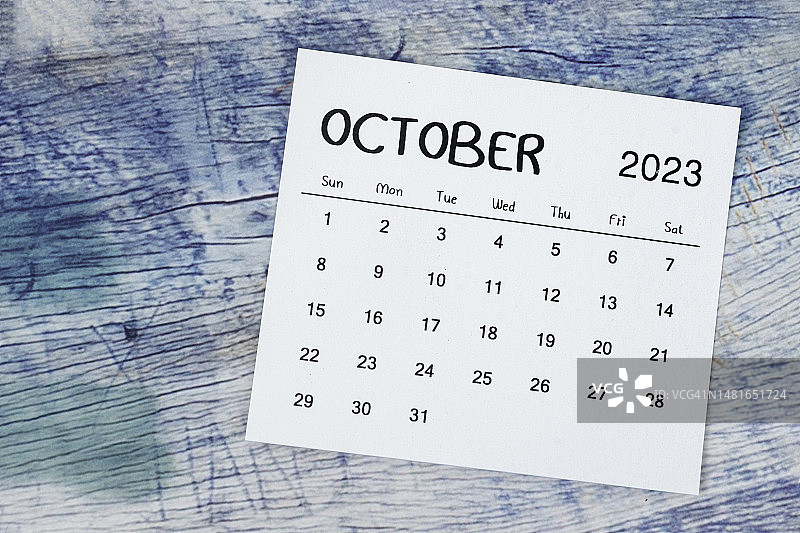 日历桌2023:10月是组织者计划和最后期限的月份，背景是蓝色的木制。图片素材