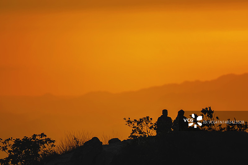 山顶上欣赏日落的情侣图片素材