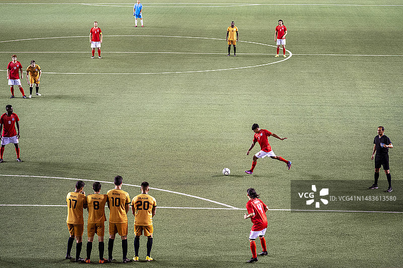 在职业足球比赛中，对方队员在任意球时围成一堵墙保护自己的球门图片素材