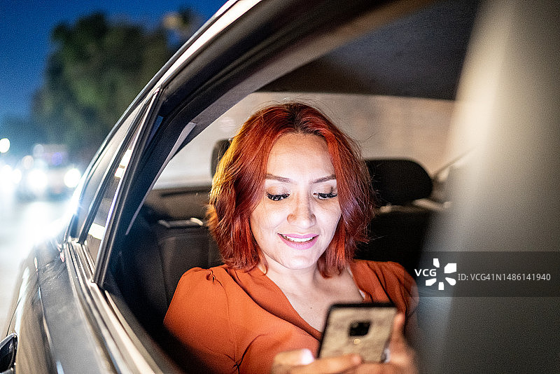 中年成年妇女在出租车驾驶过程中使用手机图片素材