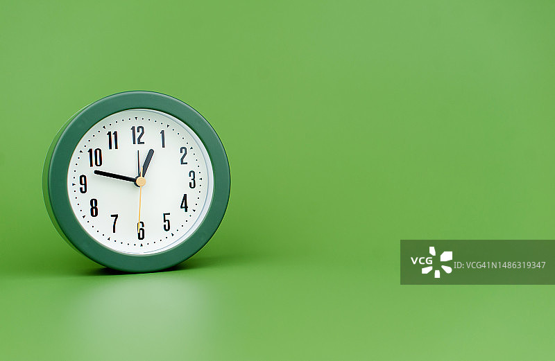 闹钟珍惜时间闹钟绿色背景上的时间概念与时间一起工作图片素材
