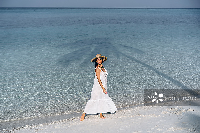 沙滩上穿白裙子的女人图片素材