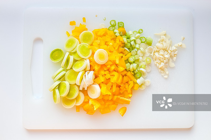切菜板上切碎的韭菜、黄椒和大蒜的特写图片素材