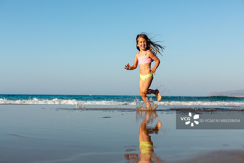 嬉戏的女孩在沙滩上奔跑图片素材