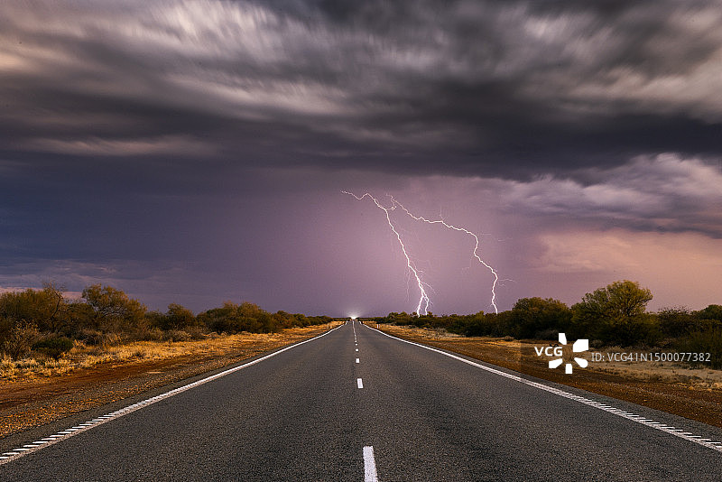 从低角度拍摄的闪电分叉和偏远的高速公路，西澳大利亚，澳大利亚图片素材