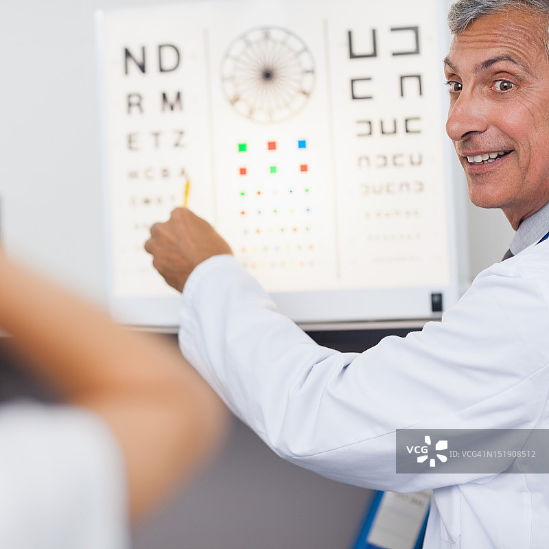 在医院里，医生微笑着给病人做视力检查图片素材