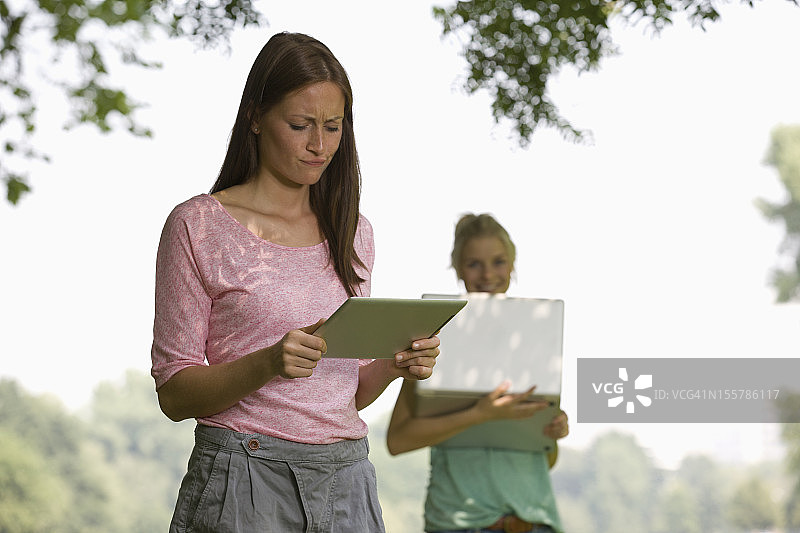 德国，北莱茵威斯特伐利亚，科隆，年轻女性使用数字平板电脑图片素材