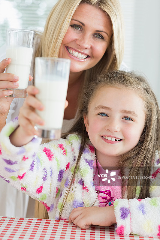 母亲和女儿举起牛奶杯图片素材