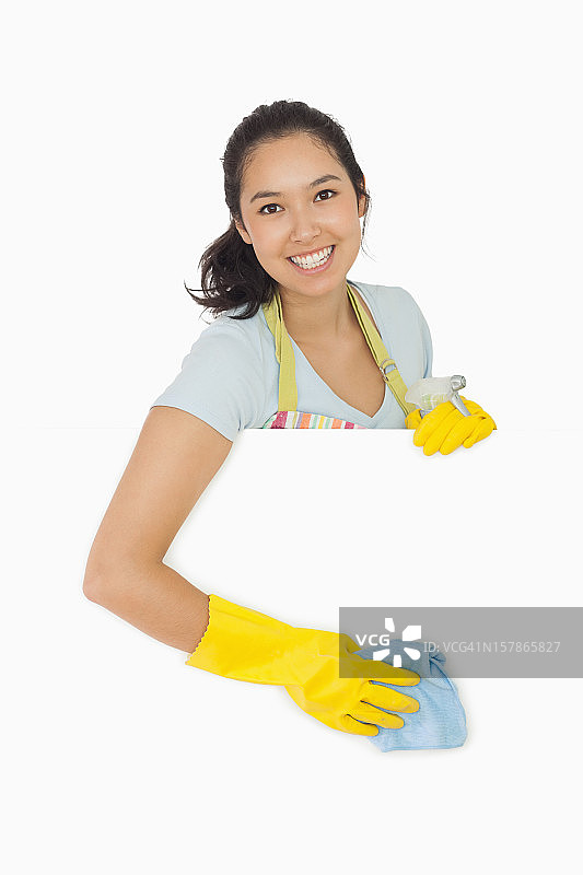 微笑的女人擦拭着白色的表面图片素材