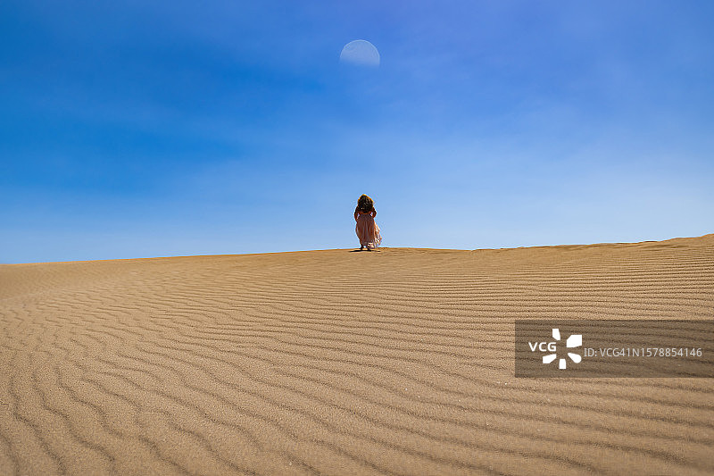 站在沙丘上的女人衬着蓝天图片素材