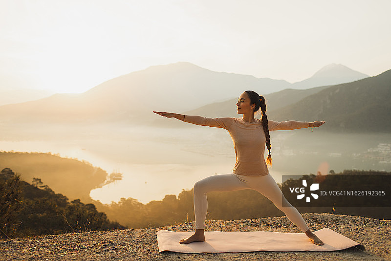 运动的女人在户外锻炼和练习瑜伽体式在日出与惊人的山景图片素材