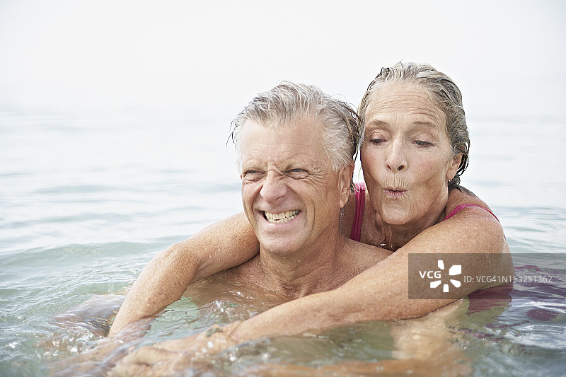西班牙，一对老年夫妇在海里游泳图片素材