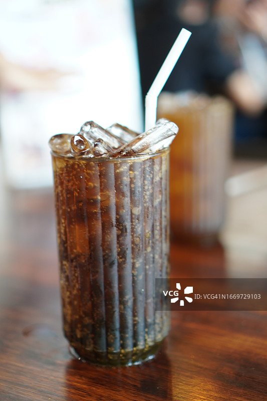 饮料、冰镇可乐装在塑料杯里，放在木桌上图片素材