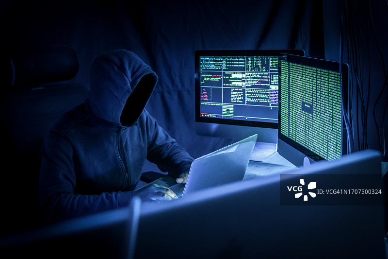 黑客在暗室里用电脑。网络犯罪。图片素材