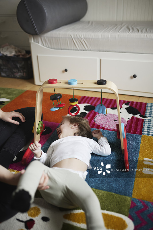 残疾女孩躺在地板上玩耍图片素材